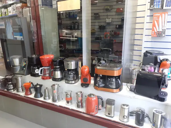 Escaparate con cafeteras, moka, hervidores y molinillos de café en la tienda